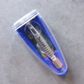 Na zdjęciu znajduje się niebieskie opakowanie z metalową, małą maszynką do golenia na żyletki.
